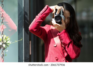 Millennial Female In Elegant Red Suit Using Vintage Retro Camera In Studio, Snapshot, Portrait, Photographer, Hobby.