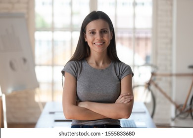 Millennial Female Worker With Arms Crossed Looking At Camera Posing Inside Of Modern Boardroom Alone, Ambitious Office Employee Portrait, Young Specialist Professional Successful Staff Member Concept