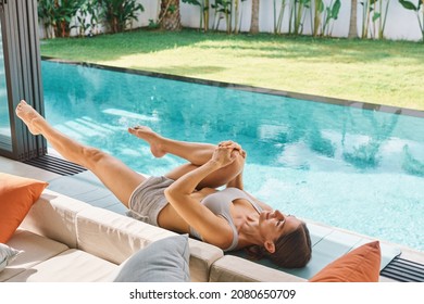Millennial fit athlete woman making yoga stretching exercises open air tropical yard villa swimming pool Thailand Early morning Hotel resort vacation getaway Health care wellbeing Outdoors Outside - Shutterstock ID 2080650709