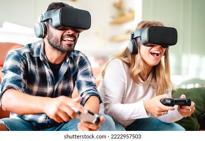 Millennial Friends Playing With Vr Glasses At Home Couch - Virtual Reality And Tech Concept With Engaged Couple Having Fun On Headset Goggles - Generation Z Digital Trends - Bright Contrast Filter