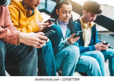 Millennial Friends Watching Smart Mobile Phone Device Outside - Young People Using Cellphones Playing On Social Media Platforms - Technology Addiction Concept