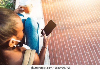 Millennial Girl With Face Mask Sitting In The City Using Mobile Smart Phone With Black Screen - Female Student Holding Phone Outside School - New Normal And Technology Concept