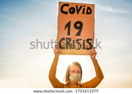 Millennial girl protest for Covid 19 economic crisis - Woman demonstrator wearing face mask for coronavirus prevention - Focus on banner