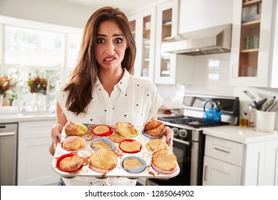 Millennial Hispanic Woman Presenting Her Cakes To Camera After A Baking Disaster, Close Up