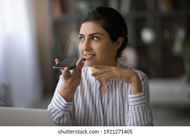 Millennial Indian woman hold modern smartphone record audio message on gadget. Young mixed race female use cellphone talk on loudspeaker or activate digital voice assistant. Technology concept. - Powered by Shutterstock