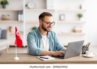 Millennial Male Tutor With Laptop Teaching Turkish Online From Home. Confident Young Man Conducting Educational Web Conference, Working For Abroad Country, Emigrating To Turkey