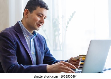 Millennial Man businessman holding credit bank card and using laptop. Online Payment, Purchase, shopping, e-commerce, internet banking, spending money, Entering Transaction.