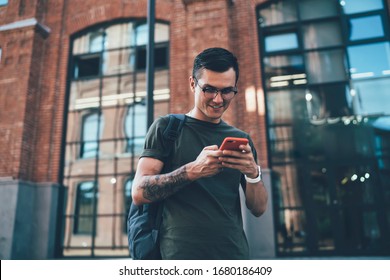 Millennial Man Sending Text Review About Application For Playing Online Games Connected To 4g Wireless On Cellphone During Leisure Time Outdoors, Positive Caucasian Male Blogger Chatting Via App