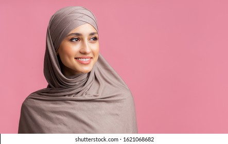 Millennial Muslim Woman. Portrait Of Attractive Islamic Girl In Hijab Looking Away Over Pink Background With Copy Space, Closeup