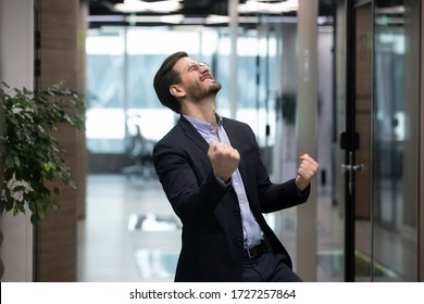 Millennial office worker in suit standing in hallway clenched fists feel overjoyed celebrate career advancement, got business opportunity, salary or sales growth, successful winner businessman concept - Shutterstock ID 1727257864