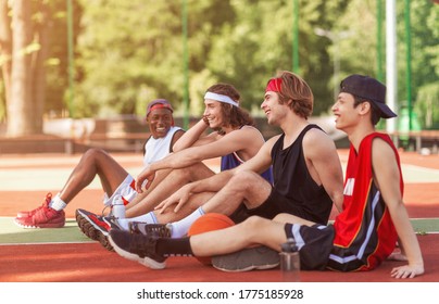 Millennial sportsmen taking break after outdoor basketball championship at stadium, copy space. Panorama - Powered by Shutterstock