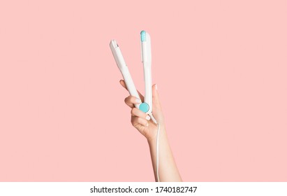 Millennial Woman Holding Hair Straightener On Pink Background, Closeup. Panorama