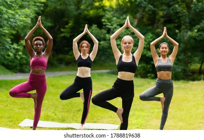 Millennial women doing balance yoga exercises on their morning class outdoors. Panorama - Powered by Shutterstock