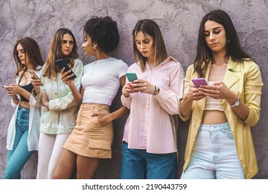 Millennial Women Only Phone Users - Girls Group Standing In Row Using Smartphones Against A Wall