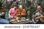 Millennials friends enjoying casual weekend meetup in garden patio, sharing social media and having coffee with snacks. Natural authentic lifestyle moments with diverse young people