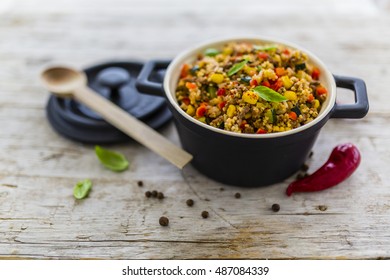 Millet Groats With Ground Beef And Vegetables And Herbs In A Pot On A Wooden Table.
