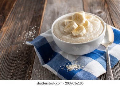 Millet Porridge With Bananas. Light Food For Breakfast. Served In A Bowl Isolated On Wooden Table