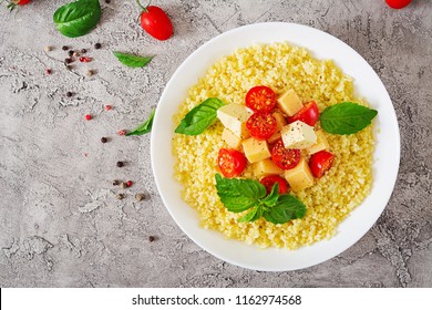 Millet Porridge With Cheese, Butter And Basil In White Bowl. Tasty Food. Breakfast. Top View. Flat Lay