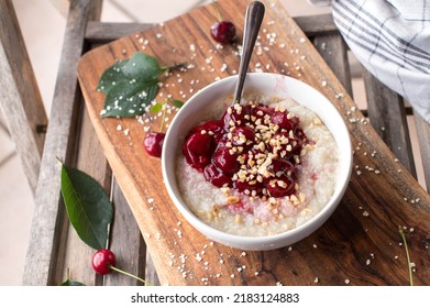 Millet Porridge With Sour Cherry Compote On Wooden Background