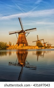 Mills In Netherland, Kinderdijk - Scenic Sunset Landscape With Windmills, Blue Sky And Reflection In The Water At Soft Light. Vertical Image, Nature Background