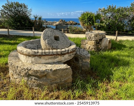 A millstone formerly used for squeezing olive oil and now used as decoration on the seaside promenade in Kissonerga, Cyprus.