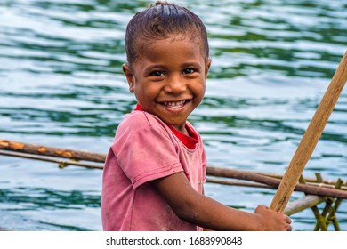 Milne Bay, Papua New Guinea - March 17th 2020 - Children Paddling In Their Local One Piece Canoes