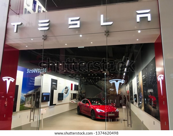 Milton Keynes, UK - 10 October 2018: A Tesla\
Elon Musk company sign outside a electric autonomous car of the\
future transportation store dealership in a shopping mall selling\
smart new vehicles.