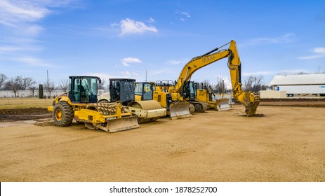 MILWAUKEE, WI, USA - MARCH 12, 2020: Yellow Caterpillar equipment sitting on a work site. This includes a backhoe loaders, compactor, excavator, and dozer.