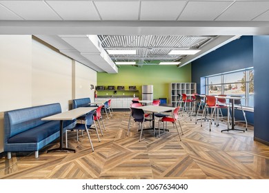 MILWAUKEE, WI, USA - MARCH 4, 2021: A Colorful Office Break Room With A Hardwood Floor, Colorful Chairs, And Tables.