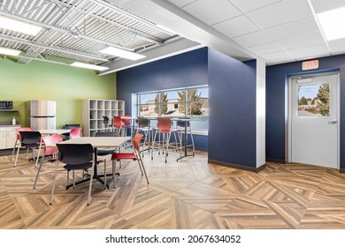 MILWAUKEE, WI, USA - MARCH 4, 2021: A Colorful Office Break Room With A Hardwood Floor, Colorful Chairs, And Tables.