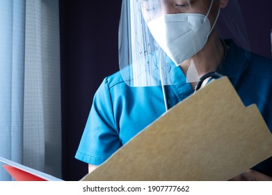 Milwaukee, Wisconsin - February 1, 2021: Male Nurse Reviewing A Patient Chart