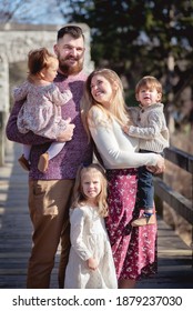 Milwaukee, Wisconsin - November 27, 2020: A Young Family Poses For A Photo On A Bridge At Hoyt Park.