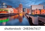 Milwaukee, Wisconsin, USA. Cityscape image of downtown Milwaukee, Wisconsin, USA with reflection of the skyline in Milwaukee River at summer sunset.