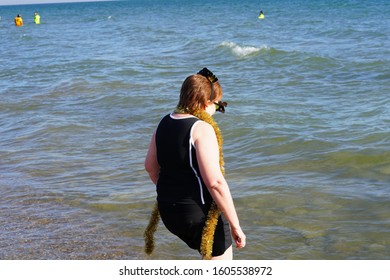 Milwaukee, Wisconsin / USA - January 1st, 2020: Middle Aged Woman Wearing 2020 New Year's Party Glasses Plunged Herself Into The Chilly Cold Waters Of Lake Michigan For The Polar Bear Plunge Event. 