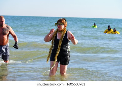 Milwaukee, Wisconsin / USA - January 1st, 2020: Middle Aged Woman Wearing 2020 New Year's Party Glasses Plunged Herself Into The Chilly Cold Waters Of Lake Michigan For The Polar Bear Plunge Event. 