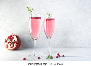 Mimosa Cocktail With Rose Champagne, Pomegranate And Rosemary In Flute Glasses,  Copy Space. Mocktail, Mimosa Sparkling Pink Drink.