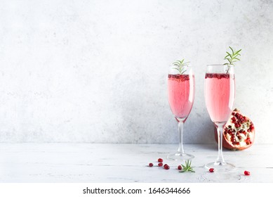 Mimosa Cocktail With Rose Champagne, Pomegranate And Rosemary In Flute Glasses,  Copy Space. Mocktail, Mimosa Sparkling Pink Drink.