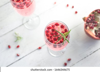 Mimosa Cocktail With Rose Champagne, Pomegranate And Rosemary In Flute Glasses,  Close Up. Mocktail, Mimosa Sparkling Pink Drink.