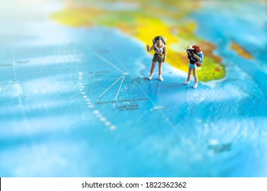 Minature People: Traveling With A Backpack Standing On World Map, Travel And Summer Concept.