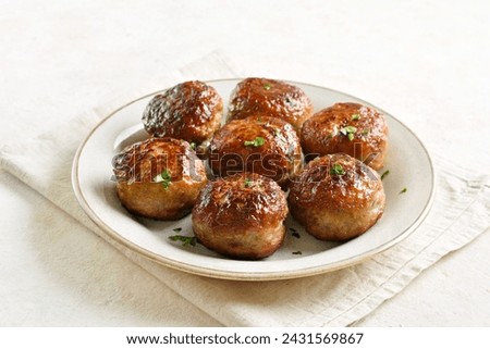 Minced pork and beef cutlets served with sauce on white plate over light background. Close up view