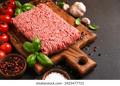 Minced pork and beef on a wooden board. Minced meat with spices on a dark background - Powered by Shutterstock