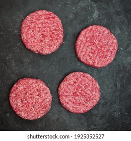 Minced Steak Burgers From Beef And Pork Meat On Black Background, Overhead View. Raw Ground Beef, Round Patties For Cooking Homemade Burger On BBQ Grill, Top View