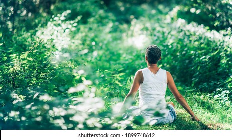 Mind Calming Inner Peace Outdoor Meditation. An Unrecognizable Mindful Woman Meditating Surrounded By Lush, Green Vegetation, Increasing Her Calmness And Inner Peace 