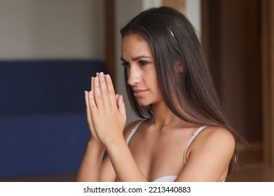 Mind Harmony. Closeup Shot Of Young Beautiful Woman Meditating With Closed Eyes, Calm Brunette Female Practicing Meditation Or Praying, Keeping Hands In Namaste Gesture Near Face.