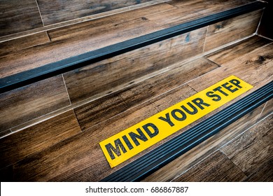 Mind your step sticker sign pasted wooden stair  Warnings  abstract  indoor architecture concept