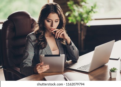 Minded attractive elegant stylish beautiful classic trendy business lady thinking about project progress, analyzing information on tablet at work place, station