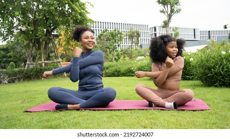 Mindful African Mom With Cute Funny Kid Daughter Doing Yoga Exercise At Park.calm Black Mother And Mixed Race Little Girl Doing Yoga In City Park Nature Together, Mum Teaching Child To Meditate.