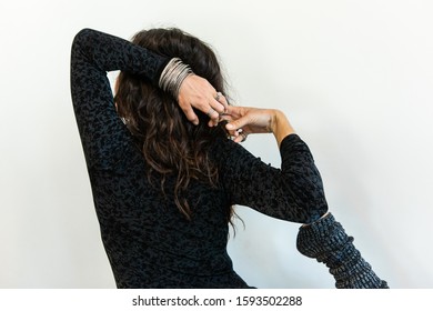 A Mindful And Empowered Woman Is Seen Wearing Black Gym Clothes As She Stretches Arms And Leg Behind Head During Vinyasa Yoga