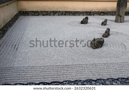 Mindful Zen garden featuring varied stone sizes—large rocks rest in fine pebbles raked into calming ripple patterns