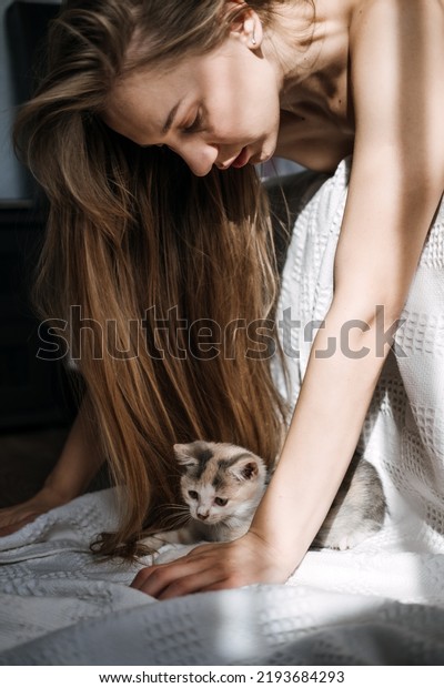Mindfulness, Being in the\
present moment, here and now. Young woman play with kitten at home\
in morning